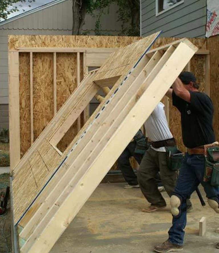 Wooden house under construction with framing and roofing in progress for custom home building.