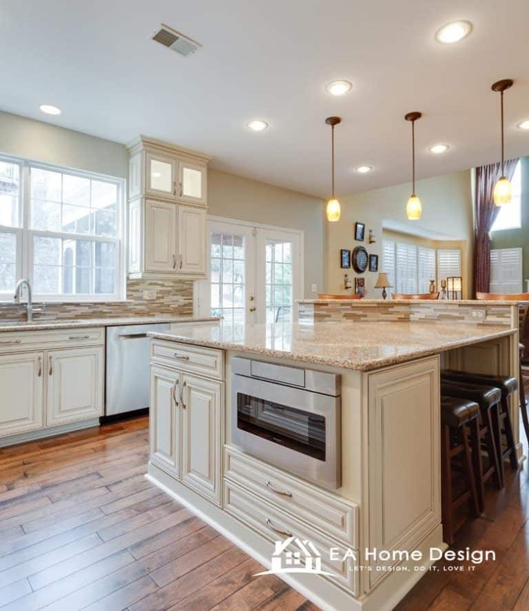 A view of a kitchen that emphasizes the rich, warm tones of the wood. The image shows the wood cabinets, a matching breakfast bar, and polished wood floors that lead the eye toward a dining area with a table and chairs in the background.
