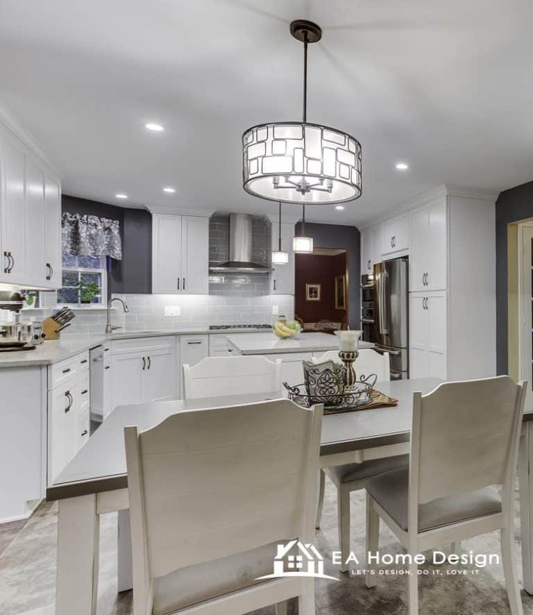 A kitchen from the dining room perspective, featuring a large, industrial-style sink, a stove with a vent hood, and an elegant pendant light over the table.