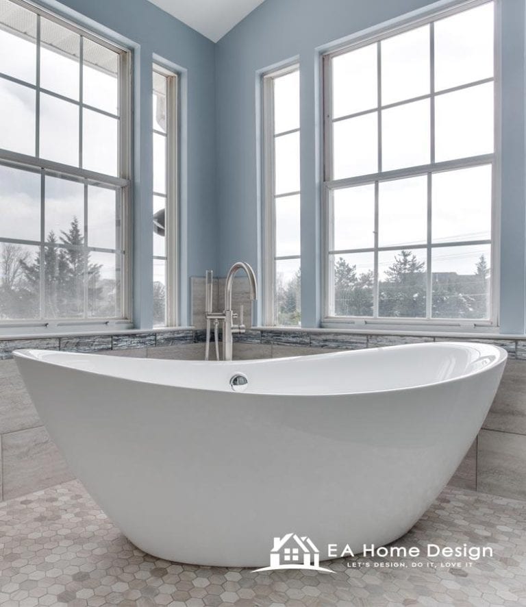 A stylish bathroom with a freestanding tub, dark hexagon tile floor, and a double vanity with open storage for towels.