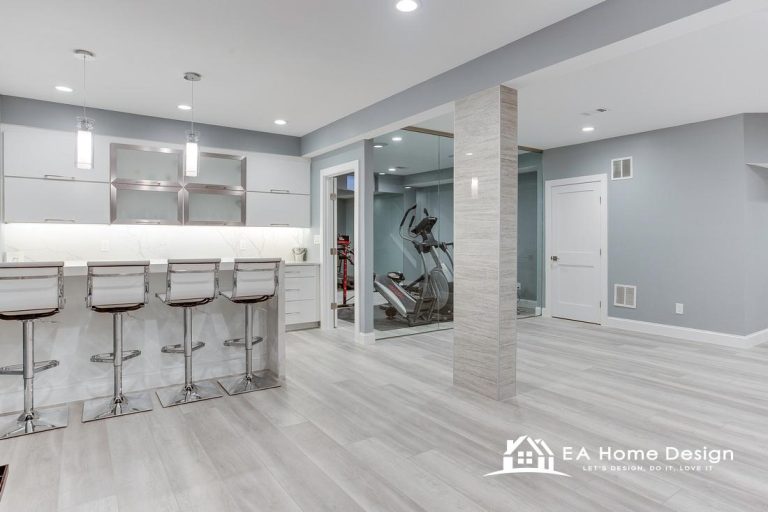 Contemporary renovated kitchen showcasing premium fittings, durable countertops, integrated appliances, warm lighting, a spacious benchtop with chairs, and modern flooring.