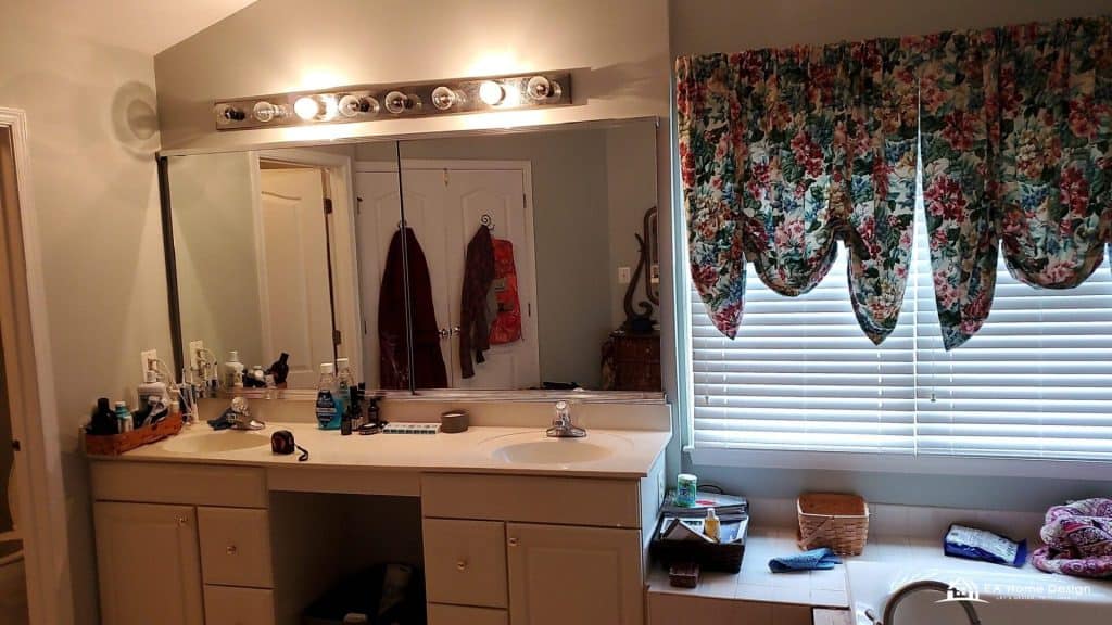 Modern kitchen with island, metal stools, white cabinets, and lighting.