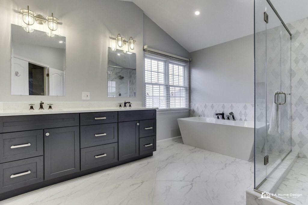 Modern kitchen with island, metal stools, white cabinets, and lighting.