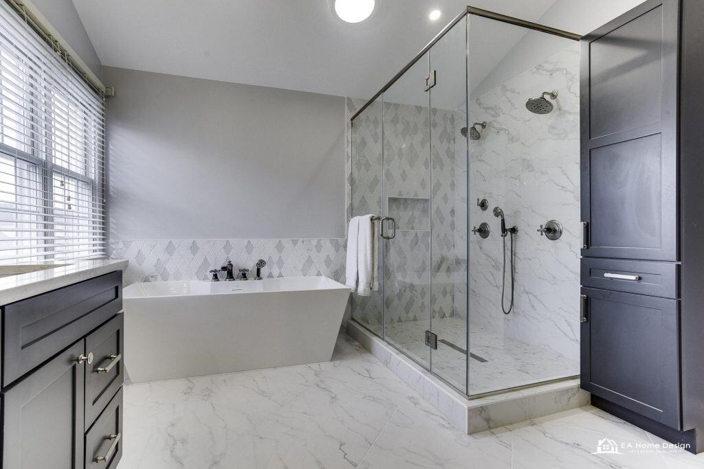 Modern kitchen with island, metal stools, white cabinets, and lighting.