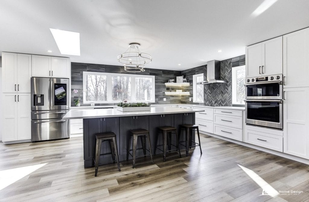 Sleek modern kitchen with white cabinetry, black island, stainless steel appliances, and natural light.