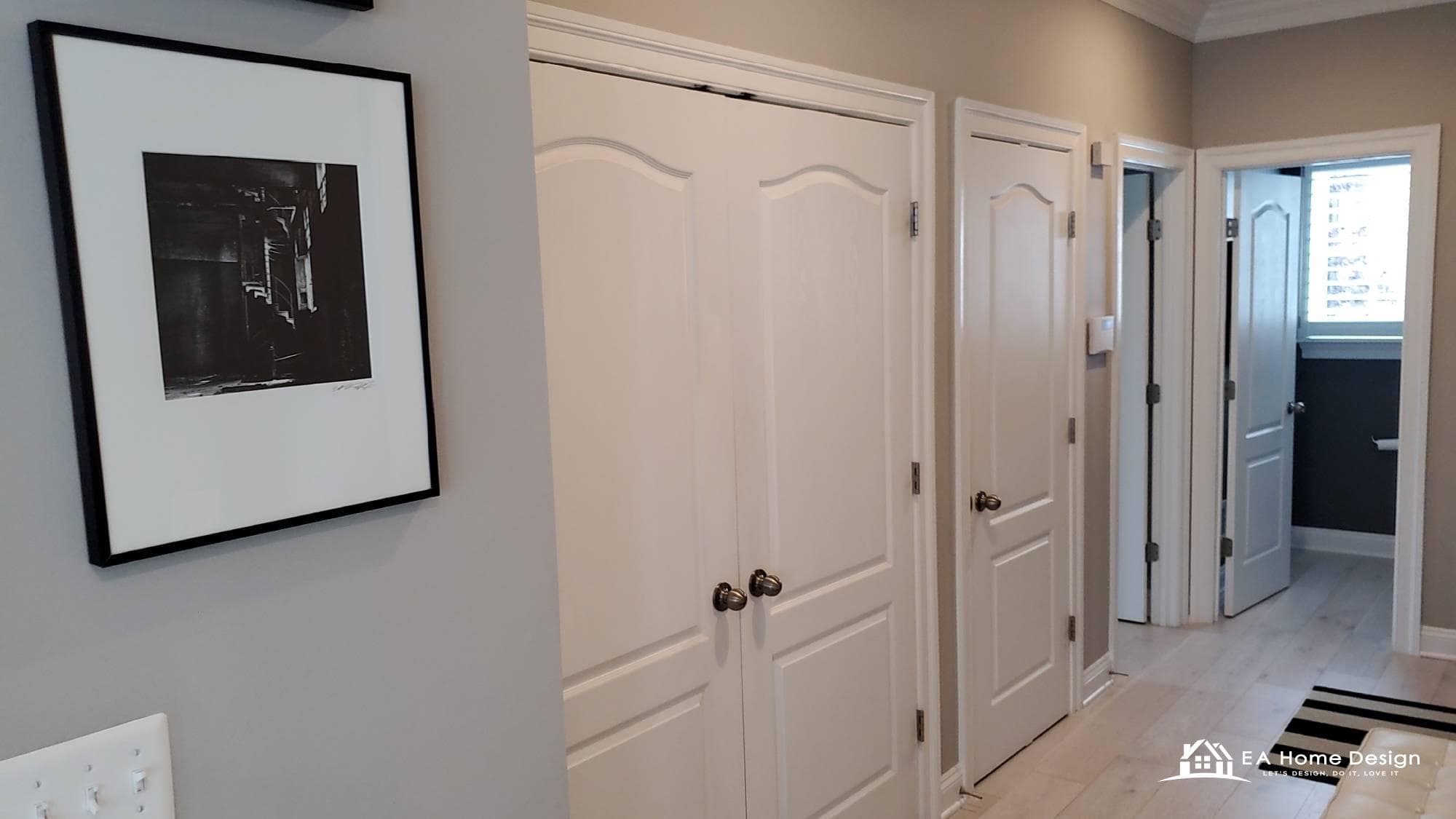 Before photo of a small upstairs hallway in Fairfax County with white bifold closet doors, grey walls and carpet