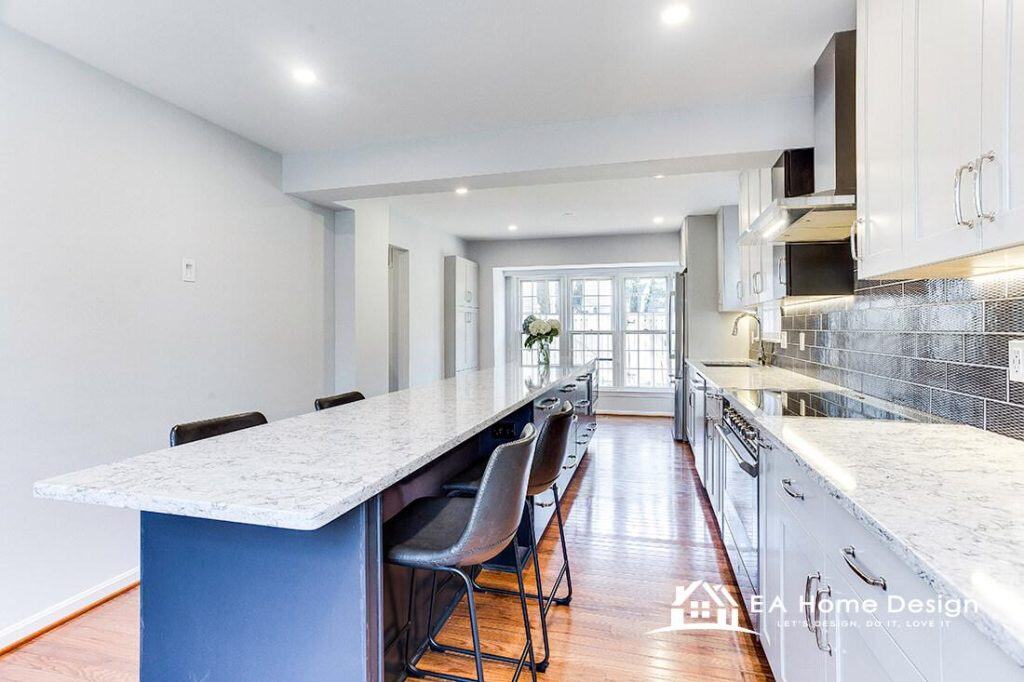 Modern kitchen design with white cabinets, marble countertops, and stylish bar seating for open-concept living