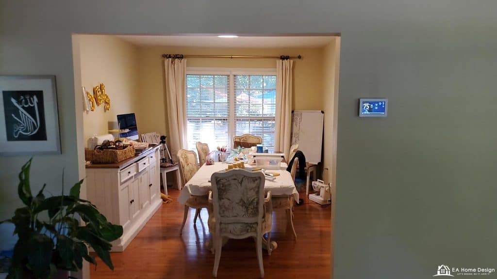 Cozy dining room with natural light, elegant furniture, and smart home thermostat for modern comfort.