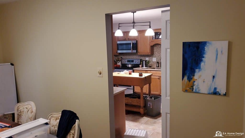 Modern kitchen with wooden cabinets and stainless steel appliances, viewed from a dining room.