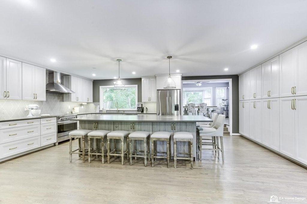Bright modern kitchen with white cabinetry, large island, stainless steel appliances, and natural light, showcasing sleek kitchen design.