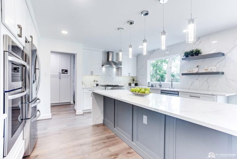 An angled shot of a kitchen, highlighting the corner sink and a modern stove, with the fridge visible on the far wall and a dining area to the side.