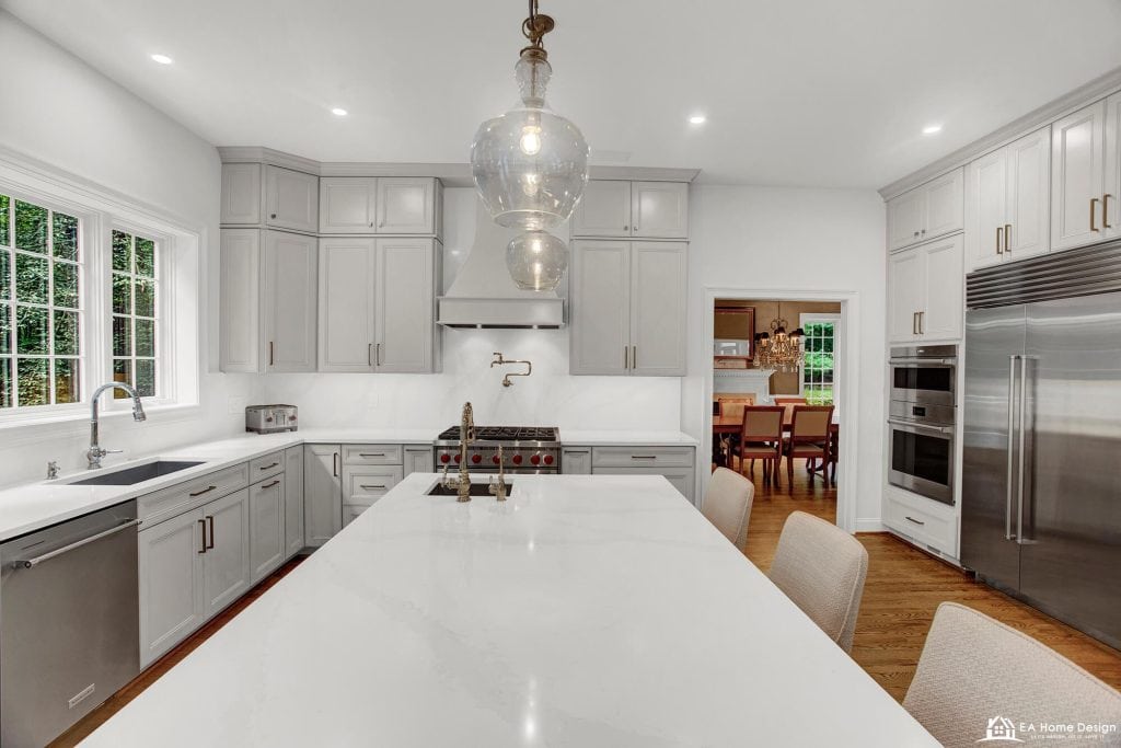 Modern white kitchen with stainless steel appliances and a large island, perfect for contemporary home design.