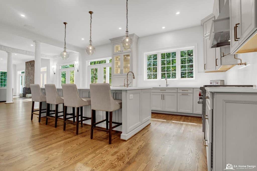Modern white kitchen with stainless steel appliances and a large island, perfect for contemporary home design.