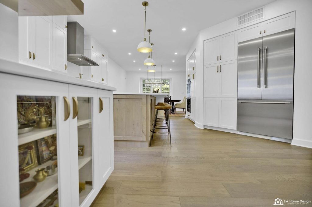 Modern white kitchen with stainless steel appliances and natural wood accents, bright and spacious interior design.