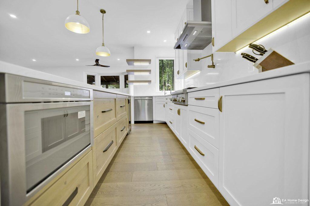 Modern white and wood kitchen with stainless steel appliances and gold accents, bright and stylish interior design.
