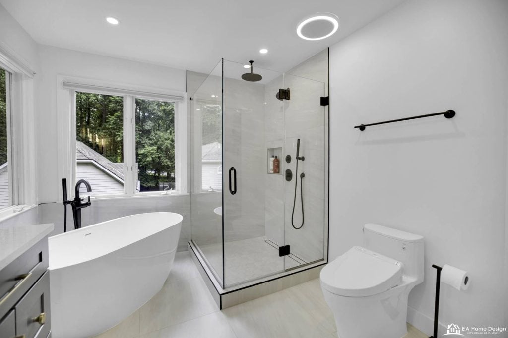 Spacious modern bathroom renovation featuring custom cabinetry, a high-end vanity, large frameless mirrors, and elegant fixtures for a luxurious and functional design.