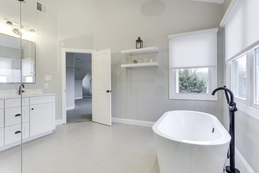 Bathroom under renovation with construction materials, exposed fixtures, and unfinished cabinetry, showing the remodeling process in progress.