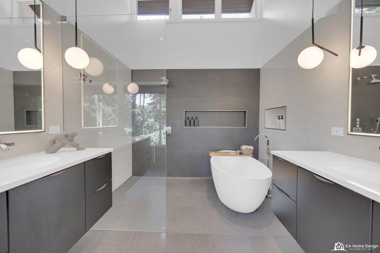 Renovated modern bathroom featuring sleek cabinets and large mirrors above the vanity, with contemporary fixtures and lighting for a clean, stylish look.