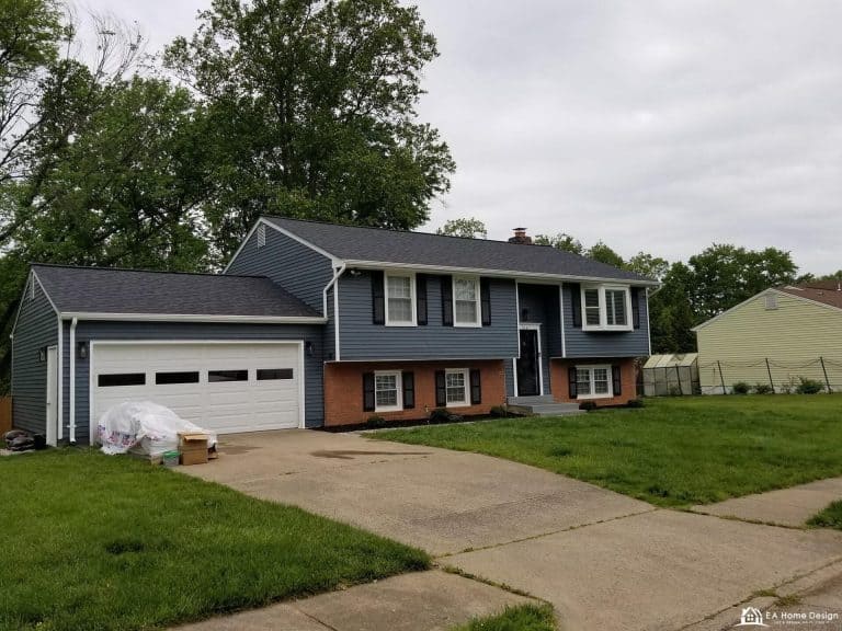 Rooftop view of residential neighborhood with trees and parked cars.