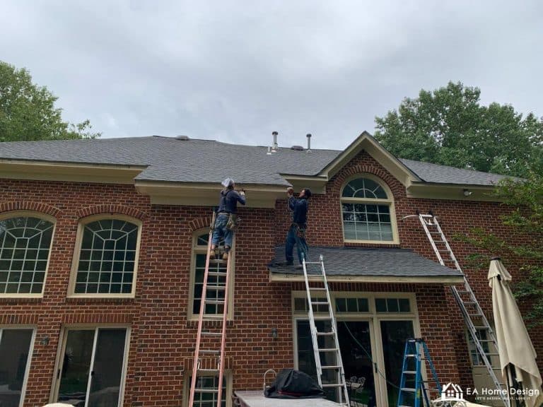 Rooftop view of residential neighborhood with trees and parked cars.