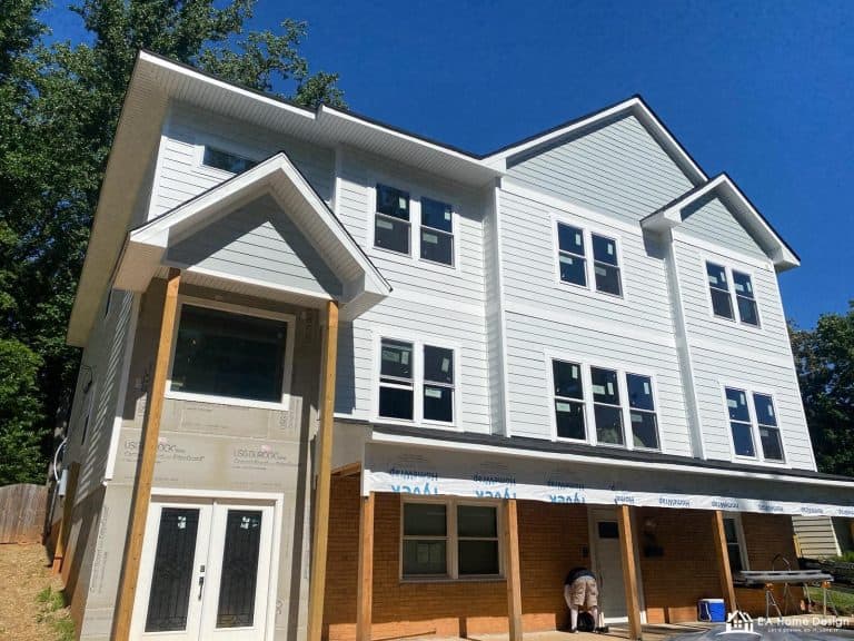 Rooftop view of residential neighborhood with trees and parked cars.
