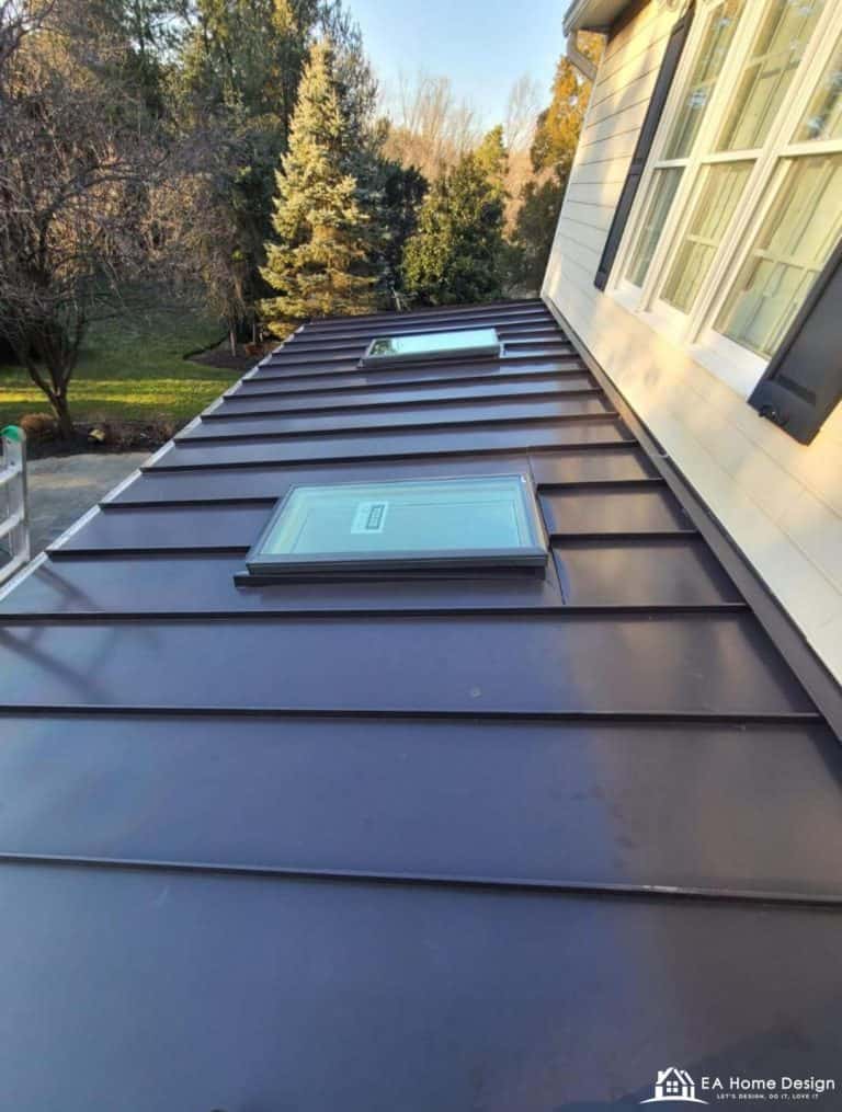 Rooftop view of residential neighborhood with trees and parked cars.
