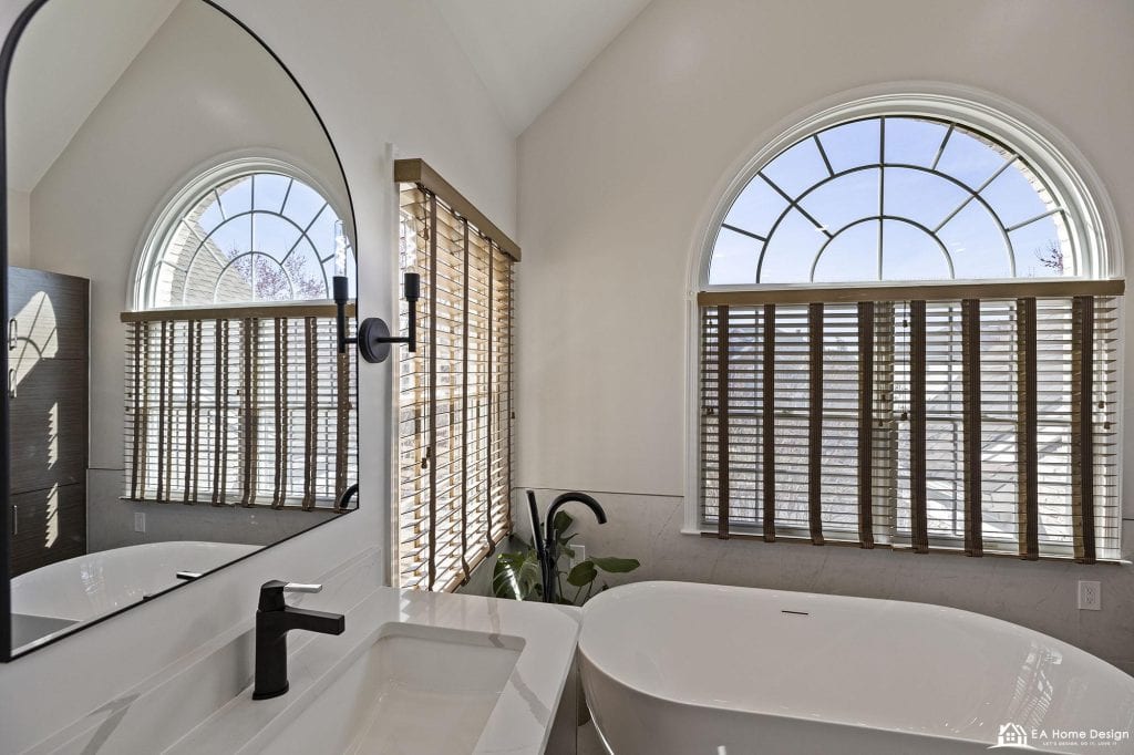 Modern marble bathroom with tub, shower, toilet, and gold accents.