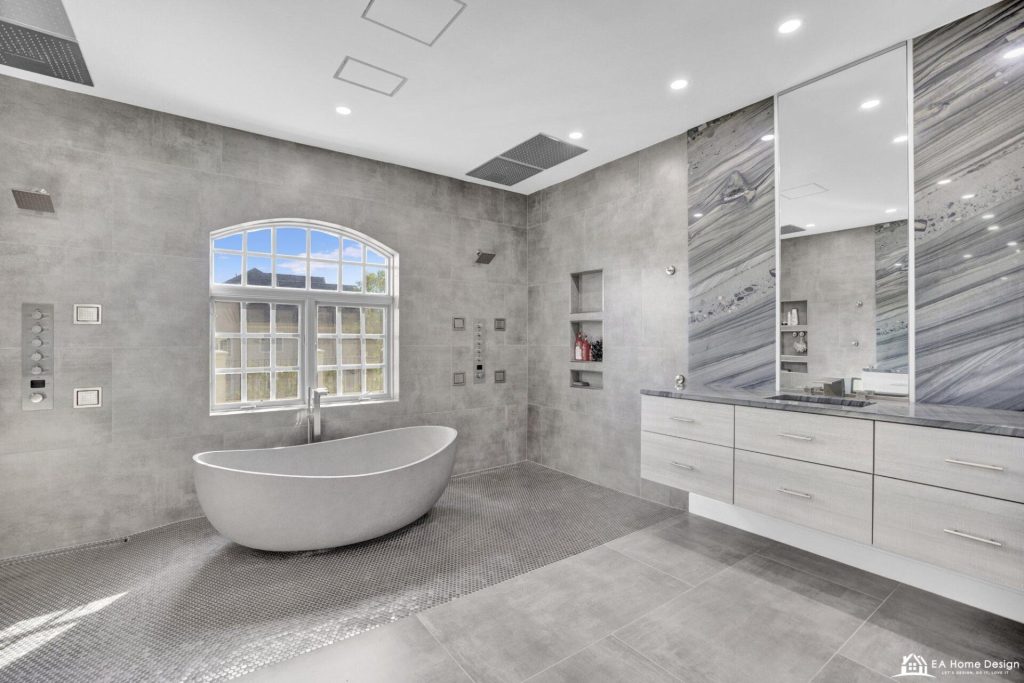 After: shower controls and body sprays on the tiled wall beside the tub, floating vanity with a marble look slab