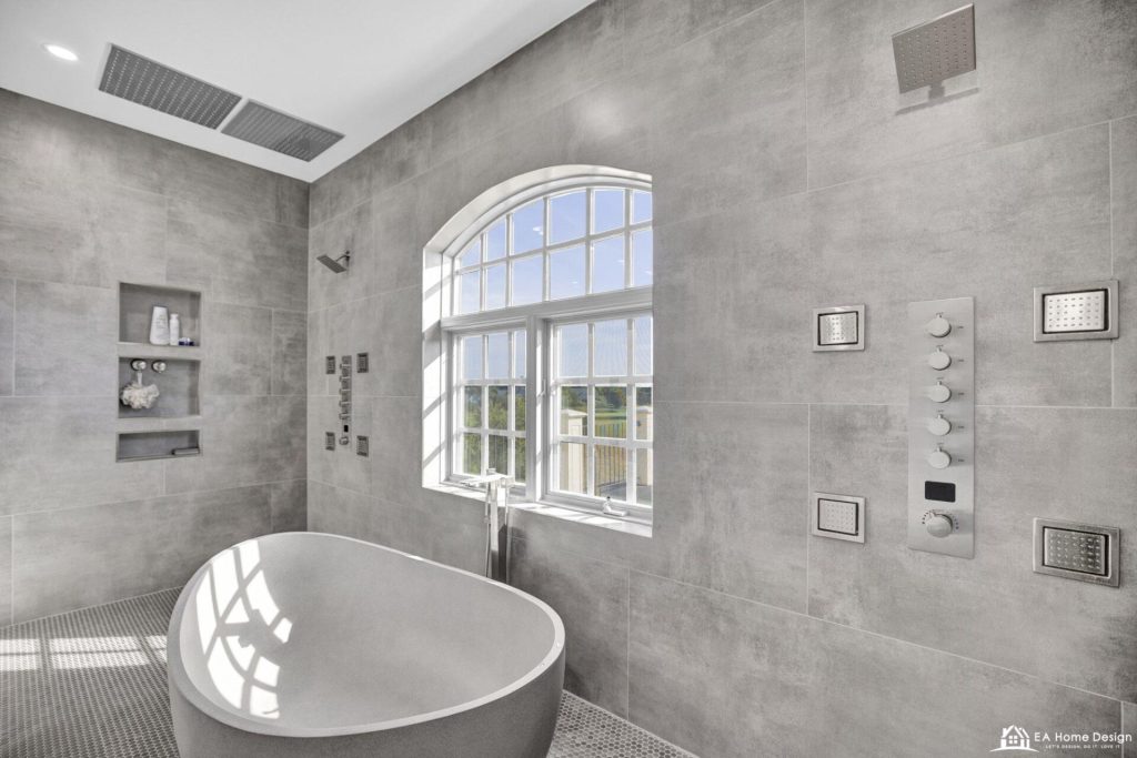 After: freestanding tub centred under the arched window with shower heads and controls on both side walls