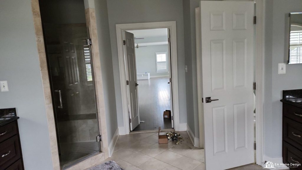 Before: the small framed shower, the doorway to the bedroom and the cherry vanity