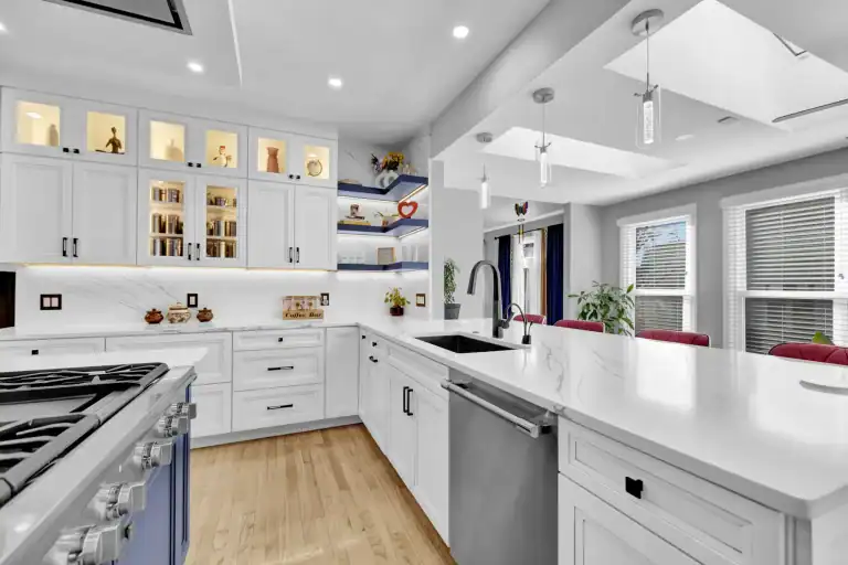 Contemporary kitchen design with blue island, white cabinets, and stainless steel appliances.