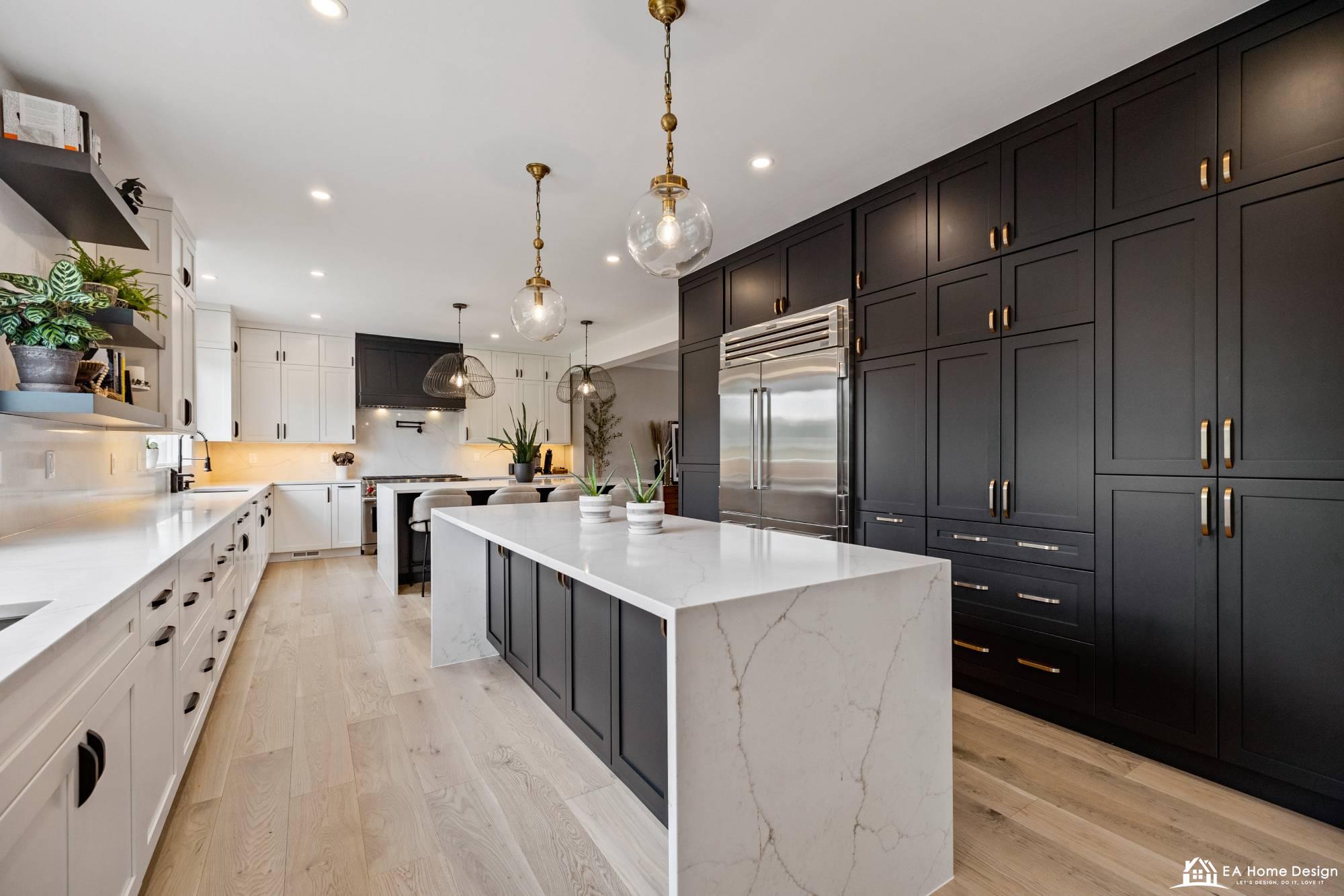 Modern kitchen with a large white island, dark gray cabinets, and stainless steel appliances.
