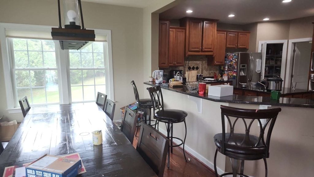 Before: dark bar counter with stools and the old cabinets, looking toward the windows