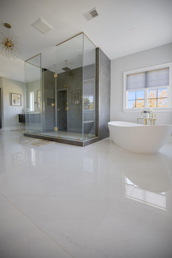 After: freestanding tub beside the walk-in glass shower under the new windows