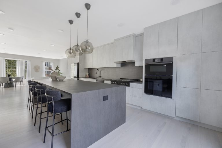 Sophisticated modern kitchen with sleek white cabinetry and black appliances.