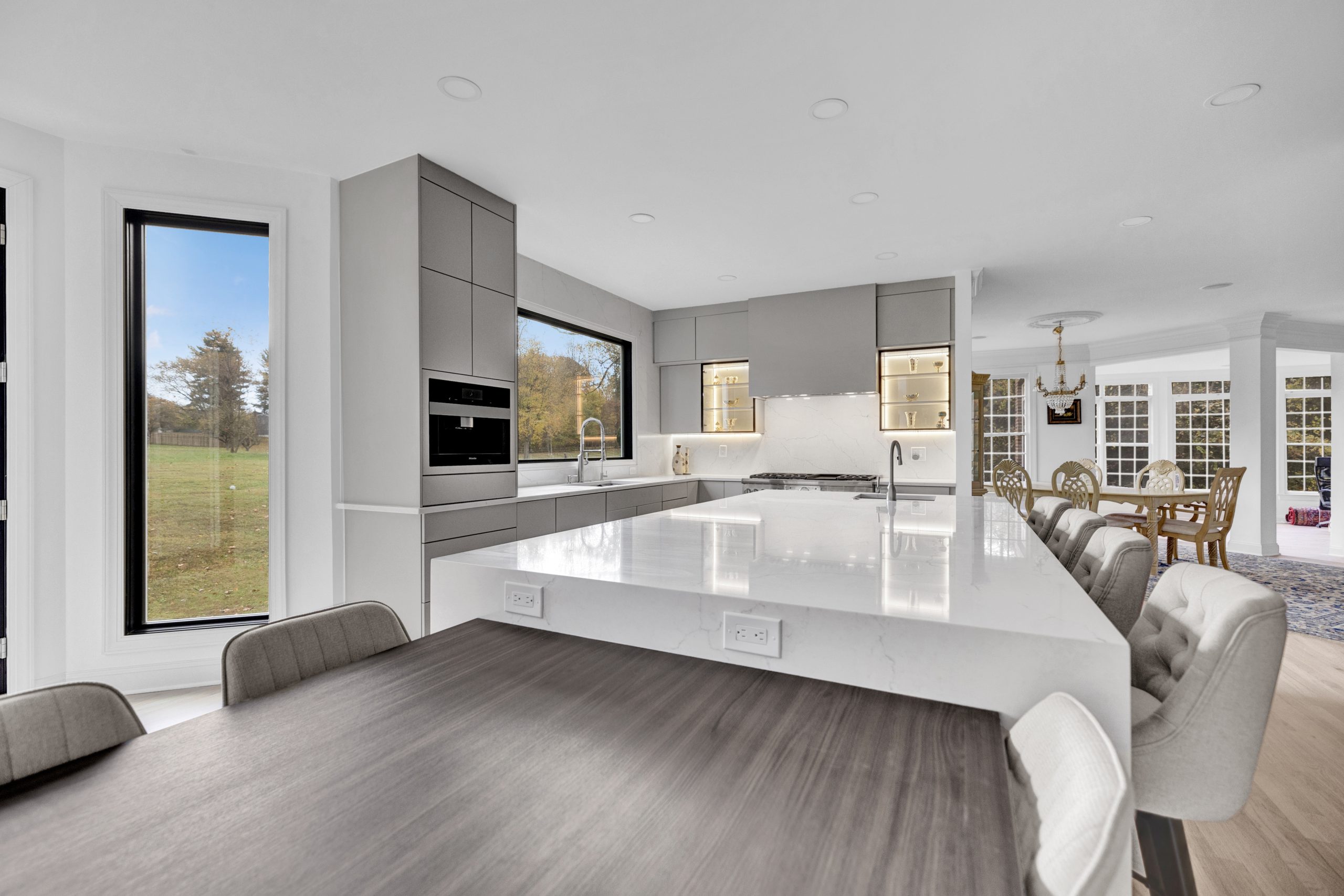 Contemporary kitchen with sleek gray cabinetry and white marble countertops.