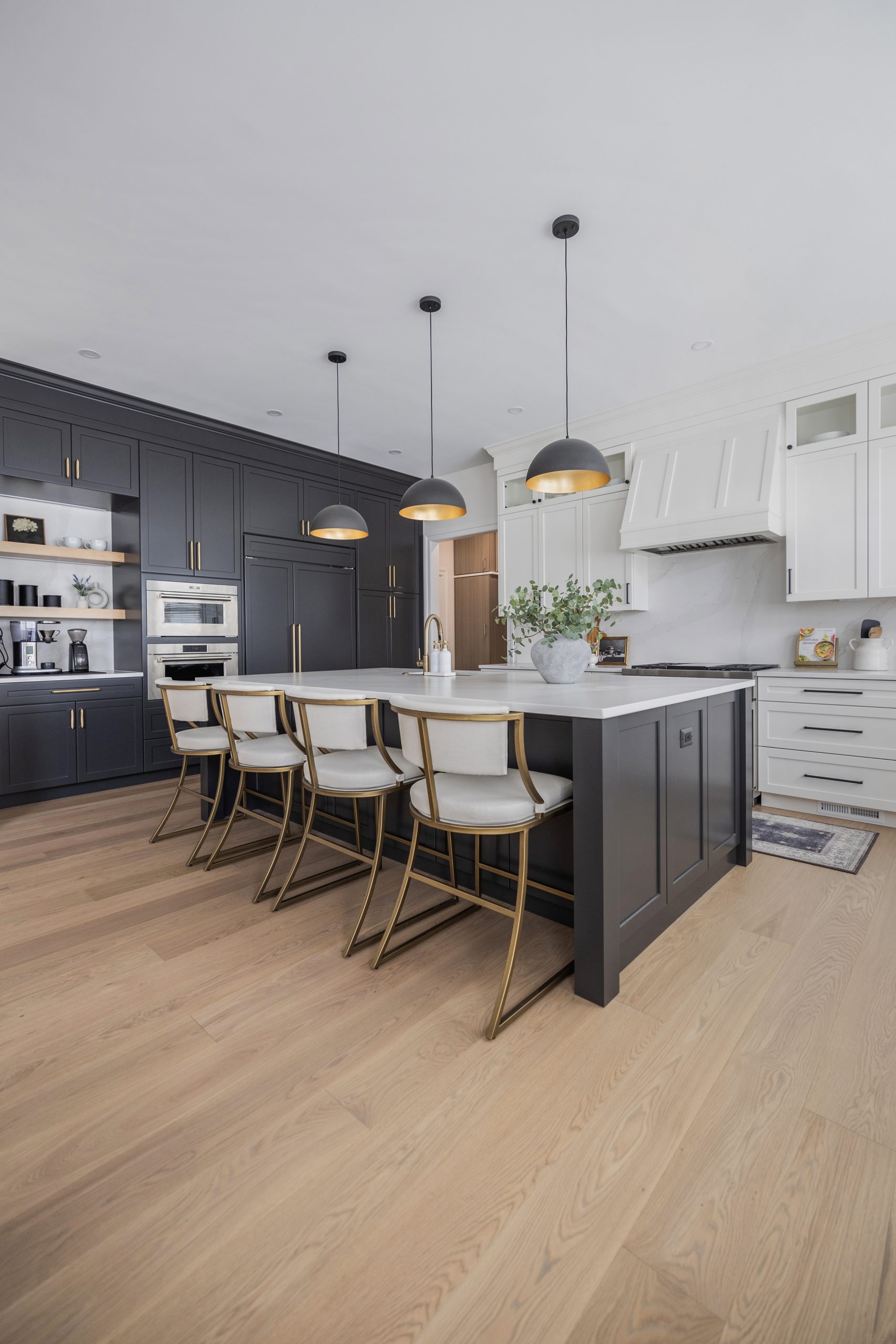 Modern black and white kitchen with sleek cabinetry and gold accents.