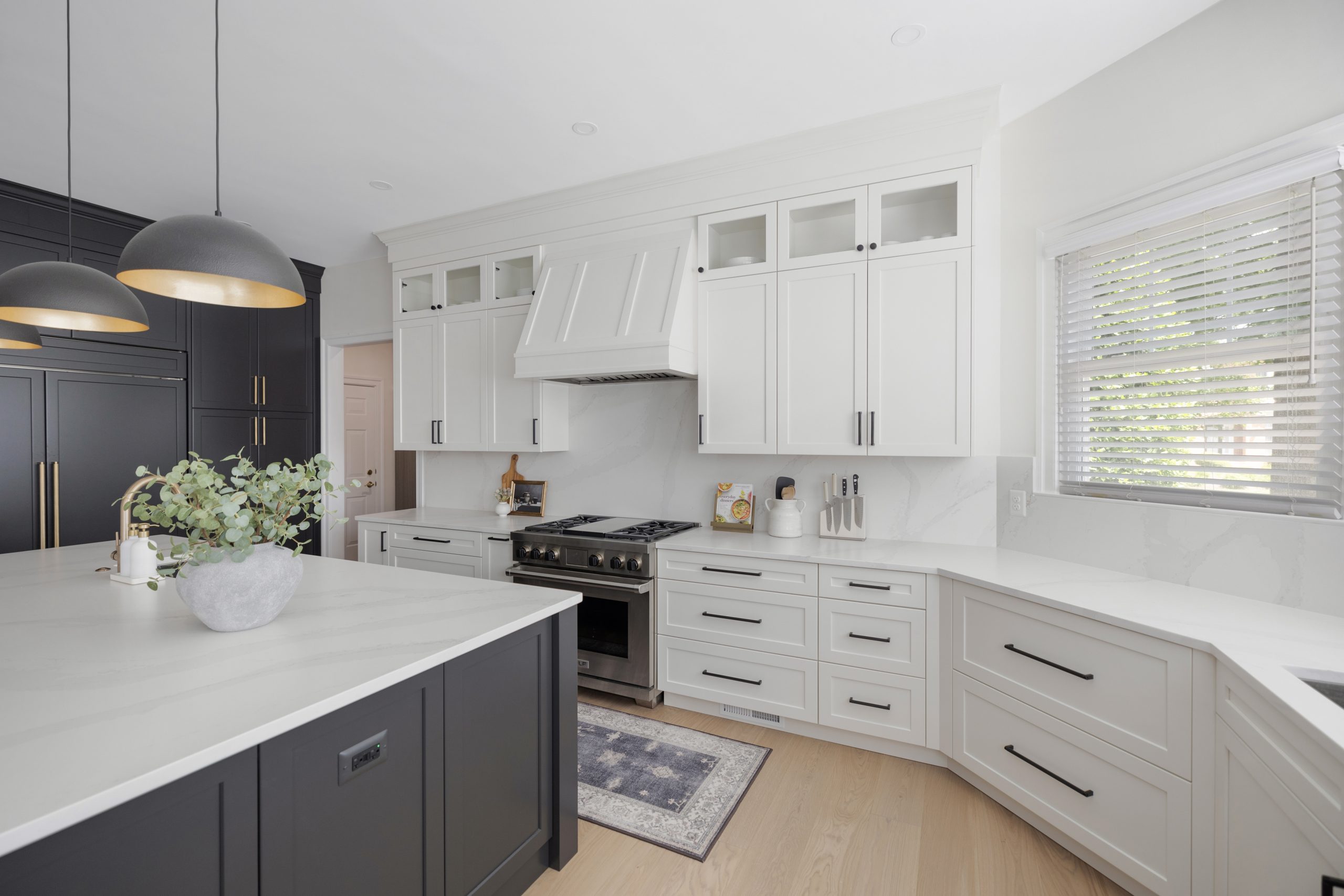 Bright kitchen with a custom white wooden range hood and matching white cabinetry, creating a clean and cohesive modern farmhouse look.