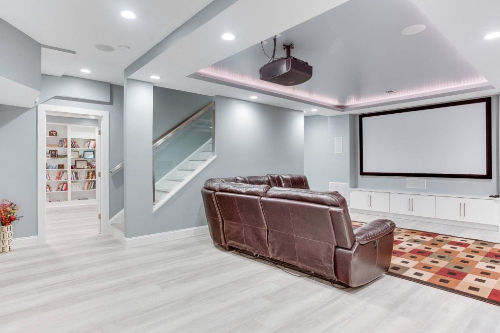 Cozy modern home theater with large projector screen and comfortable leather seating.