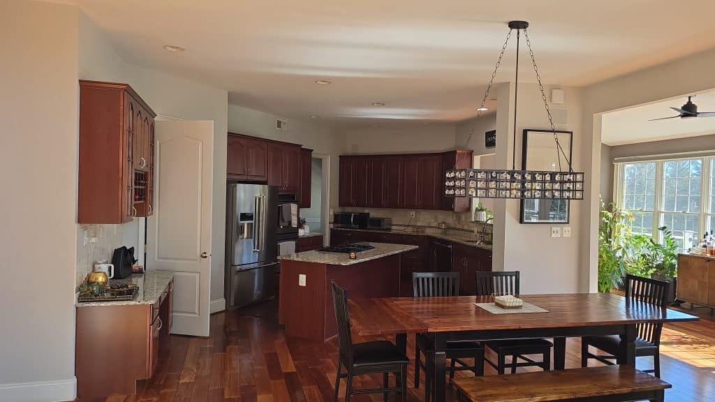 Elegant kitchen with dark wood cabinets, granite countertops, and a spacious dining area with natural light.