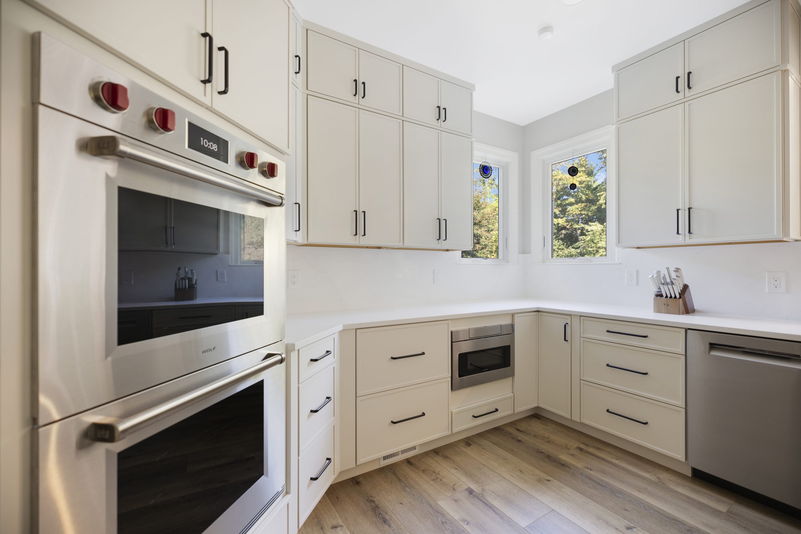 Modern EA Home Design kitchen with white cabinets, marble countertops, and a large island