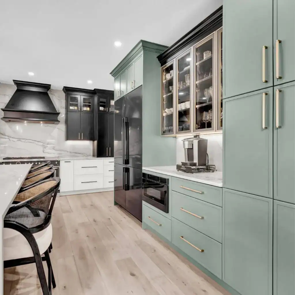Modern kitchen with mint green cabinets, black appliances, gold handles, and light wood flooring—perfect inspiration for your next home improvement in Fairfax County, VA. Marble backsplash and woven barstools complete this elegant look.
