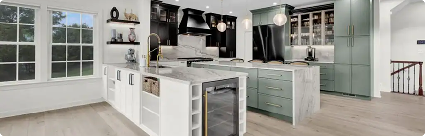 Modern kitchen with white and green cabinetry, marble countertops, gold fixtures, pendant lighting, large island with seating, built-in wine fridge, open shelves, and stainless steel appliances. Large windows provide natural light.