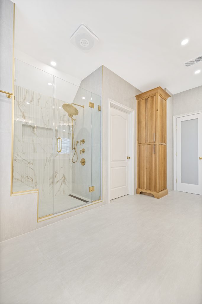 After: the gold framed shower beside the door and linen cabinet