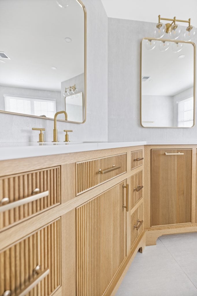 After: close-up of the reeded white oak vanity with gold hardware and quartz top