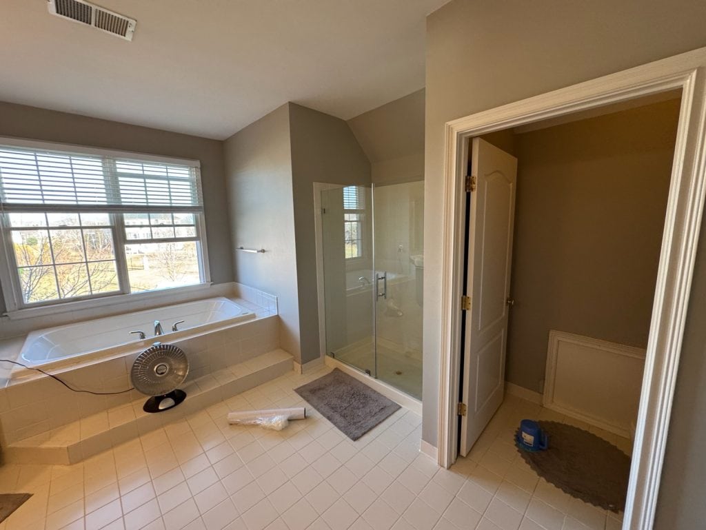 Before: the drop-in tub deck under the window next to the small framed shower
