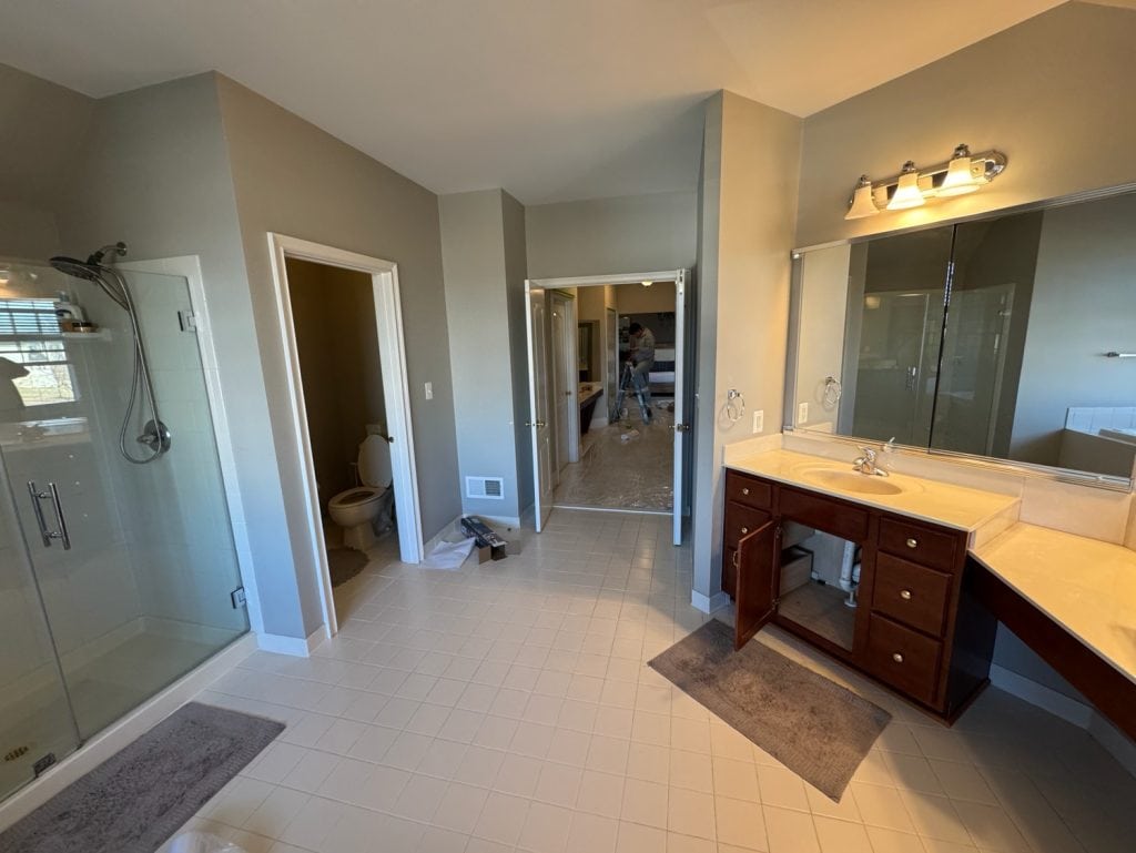 Before: the original shower, toilet room and cherry vanity by the door