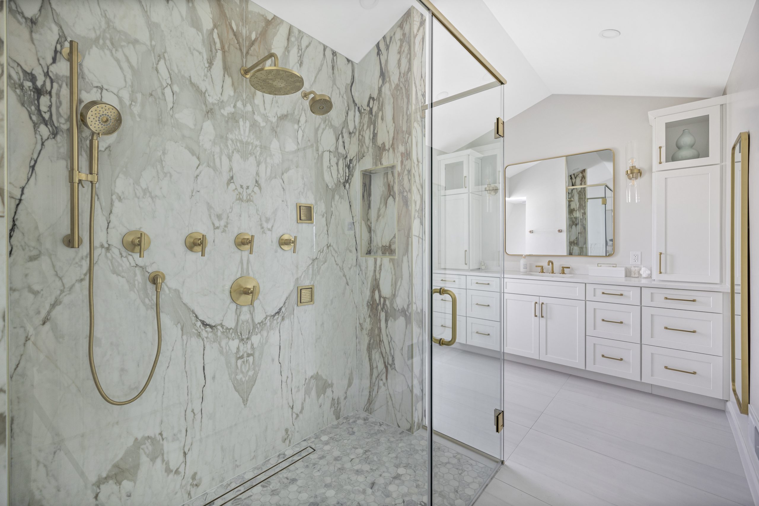 Remodeled primary bathroom in Northern Virginia with marble shower and gold fixtures