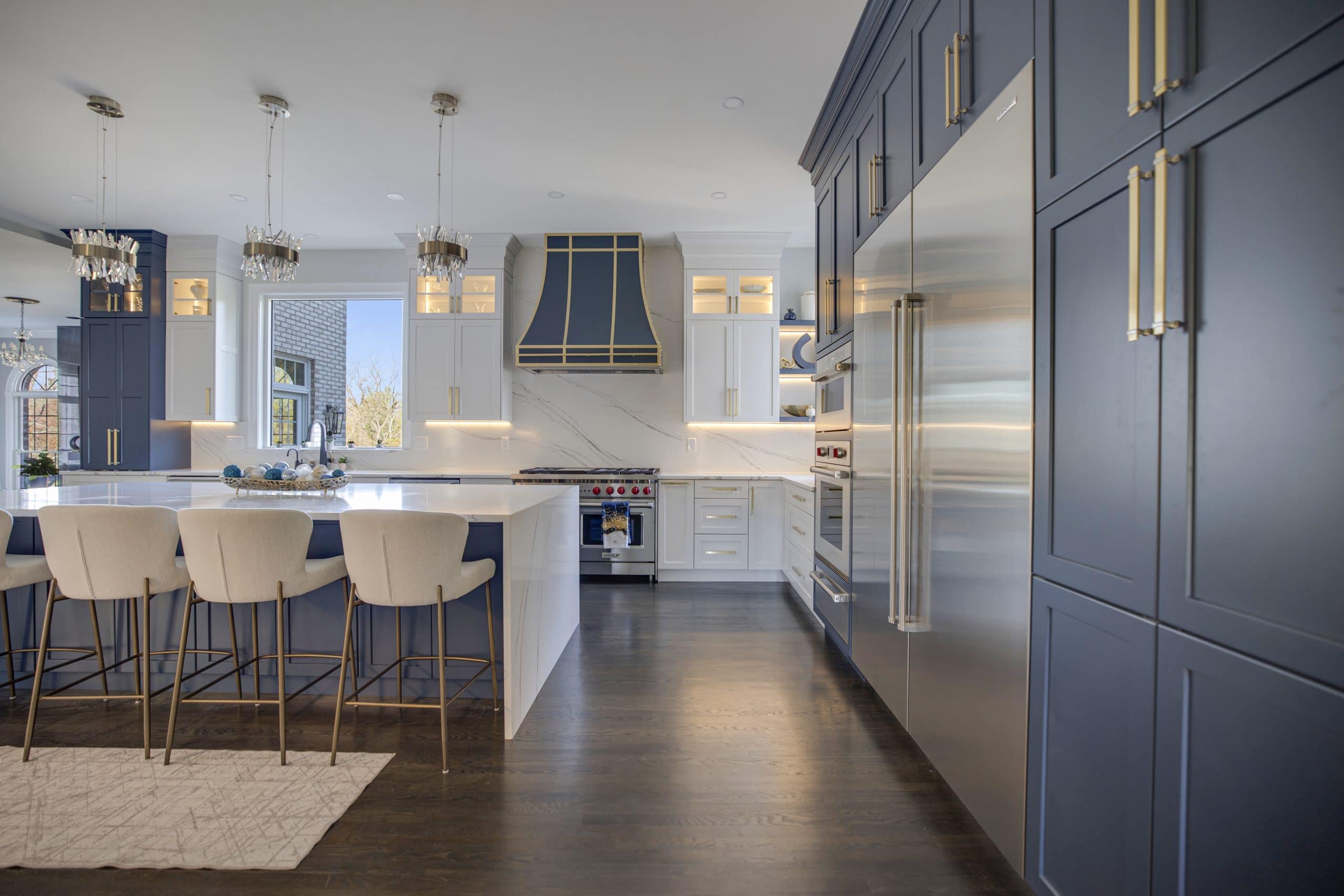 Navy cabinetry with gold hardware and a white island in a remodeled Northern Virginia kitchen