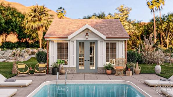 A small pool house with patio seating overlooks a sunny backyard swimming pool, surrounded by lush plants.